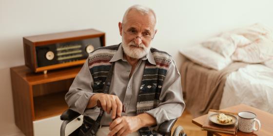 man in wheelchair holding stick