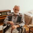 man in wheelchair holding stick