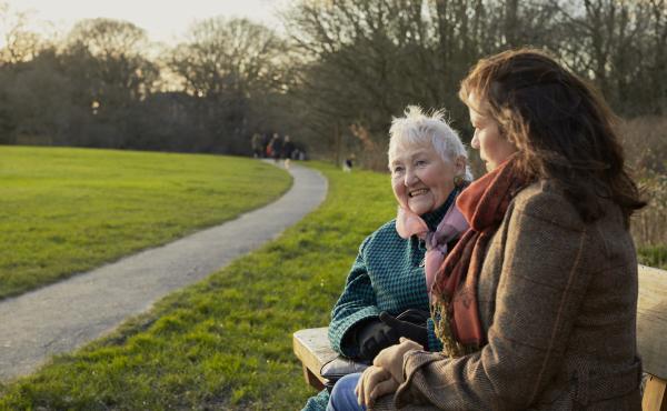 Older women laughing on a park bench