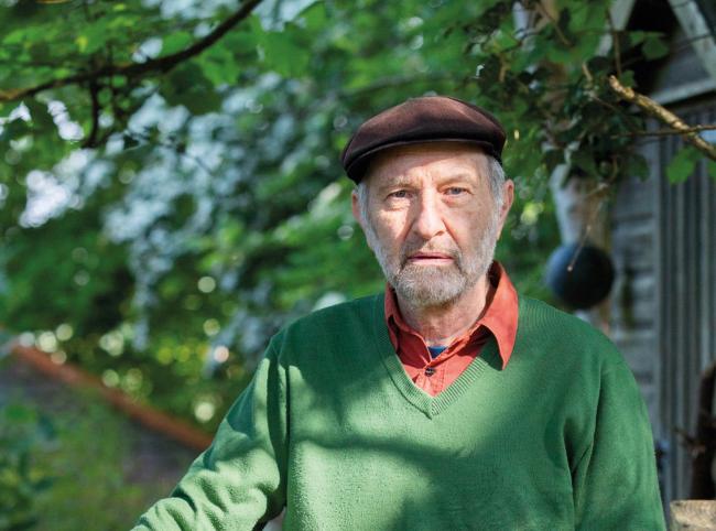 Man wearing flat cap with trees in background